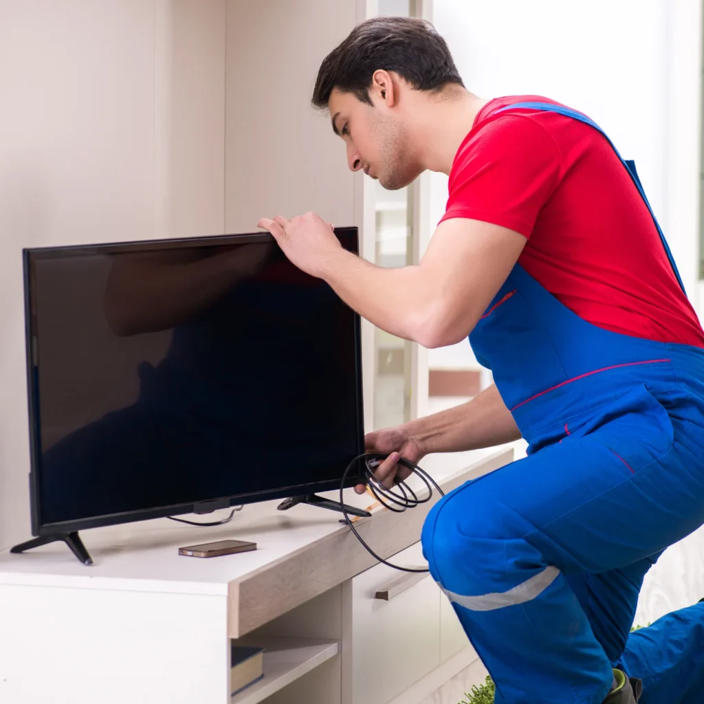 Technician servicing television at customer home